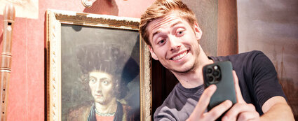 Junger Mann macht Selfie mit historischem Porträt auf der Leuchtenburg