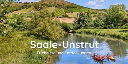 zwei Kanufahrer auf deinem Fluss, im Hintergrund Weinberge und blauer himmel