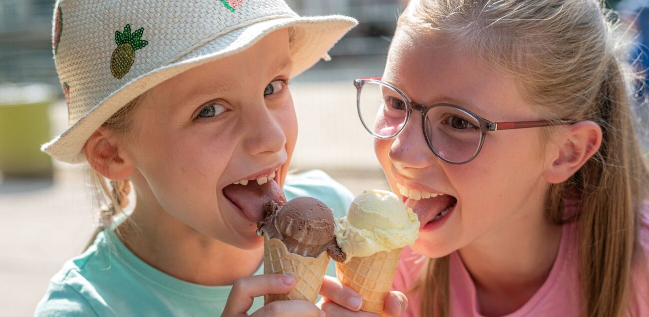 zwei Mädchen lecken gemeinsam an einem Eis