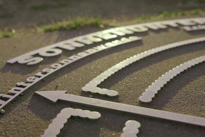 Sichtpfeil in Richtung Sonnenuntergang auf der Windrose im Mittelpunkt des Sonnenobservatoriums Goseck