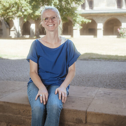 Hemmi Eckardt sitzend und lächelnd im Gesamtporträt