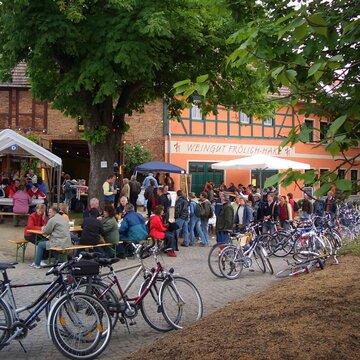 Besucher bei einer Veranstaltung vor einem Weingut