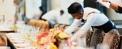 Azubi der Gastronomie dekoriert Tisch