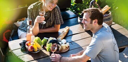 Junges Paar isst an Tisch auf einer Terrasse