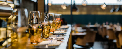 Detailaufnahme von einer mit Gläsern und Tellern gedeckten Bar