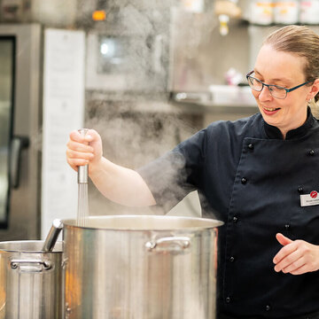 Köchin kocht in der Küche des Weinberghotel Edelacker