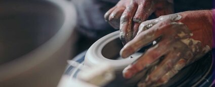 zwei Hände formen auf einer Töpferscheibe in Bürgel eine Keramik