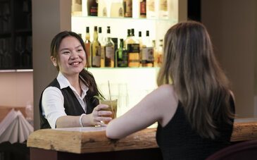 Sydney Gunawan, Azubi, beim Servieren eines Cocktails