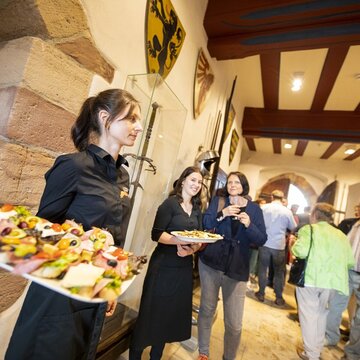 Junge Frau mit Tablett in der Hand, auf welchem Speisen schön aufbereitet sind, bei einer Veranstaltung auf der Leuchtenburg., 