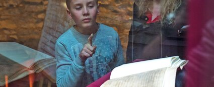 Kind bestaunt die Merseburger Zaubersprüche im Merseburger Dom