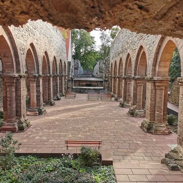 barrierefrei zugängliche Kirchenruine im Kloster Memleben: Links und rechts sind Spitzbogen-Arkaden zu sehen, dazwischen Besplanzung. Der Boden ist ebenerdig ausgebaut.