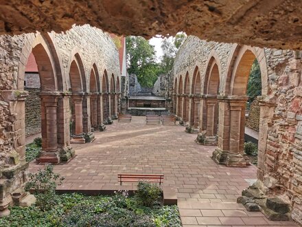 barrierefrei zugängliche Kirchenruine im Kloster Memleben: Links und rechts sind Spitzbogen-Arkaden zu sehen, dazwischen Besplanzung. Der Boden ist ebenerdig ausgebaut.