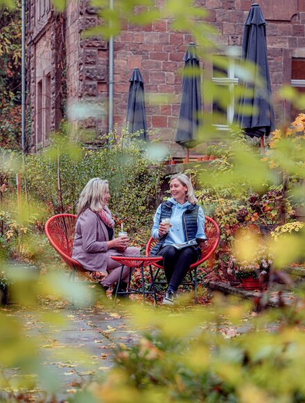 zwei Frauen genießen Café im herbstlichen Garten von Schloss Zingst