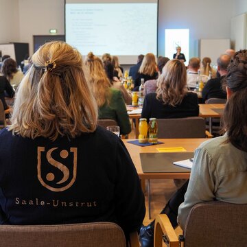 Eine Gruppen von Menschen führt eine Beratung in einem Tagungsraum durch