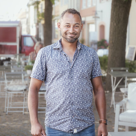 Manuel Flechtner draußen unter einem Baum im Ganzkörperporträt