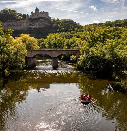 Schlauchboottour auf der Saale bei Bad Kösen, auf dem Weg liegt eine Brücke, darüber liegt die Rudelsburg auf dem steilen Felsen.