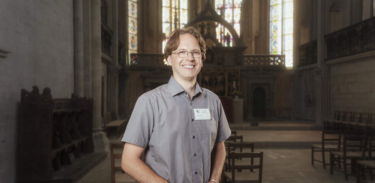 Henry Mill steht strahlend vor dem Altarraum des Naumburger Doms