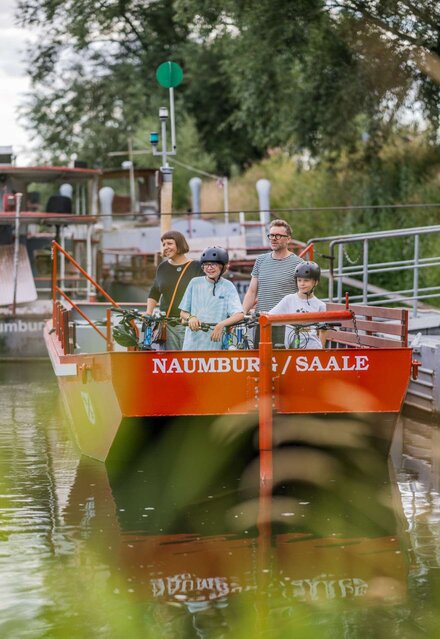 Familie mit Fahrrädern nutzt die Fähre über den Fluss im Naumburger Blütengrund
