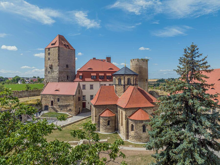 Burg Querfurt im Sonnenlicht und mit Bäumen