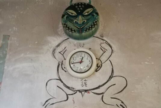 sog. Zeitteufel im Bauhaus-Werkstatt-Museum Dornburg: Er besteht aus einer runden Uhr als Bauch, einem getöpferten Teufelskopf darüber und einem auf die Wand gemalten Teufelskörper