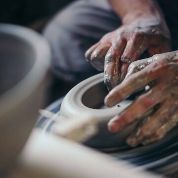 zwei Hände formen auf einer Töpferscheibe in Bürgel eine Keramik