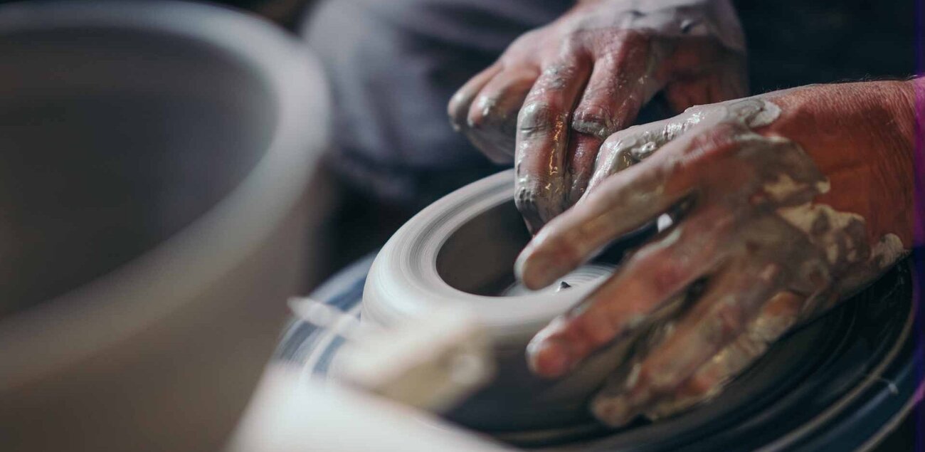 zwei Hände formen auf einer Töpferscheibe in Bürgel eine Keramik