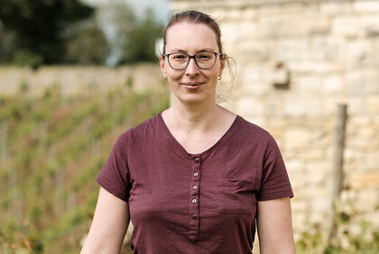 Portrait von Nicole Liebetrau, Küchenchefin im Weinberghotel Edelacker, stehend im Freien