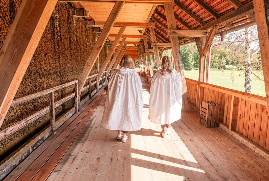 Zwei Frauen in weißen Umhängen betreiben Freiluftinhalation am Gradierwerk Louise in Bad Sulza