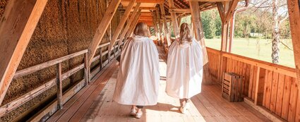 Zwei Frauen in weißen Umhängen betreiben Freiluftinhalation am Gradierwerk Louise in Bad Sulza