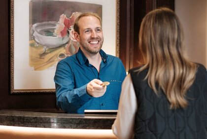 Pascal Zeymer, Hoteldirektor Parkhotel Güldene Berge, übergibt an der Rezeption einen Schlüssel an einen Gast