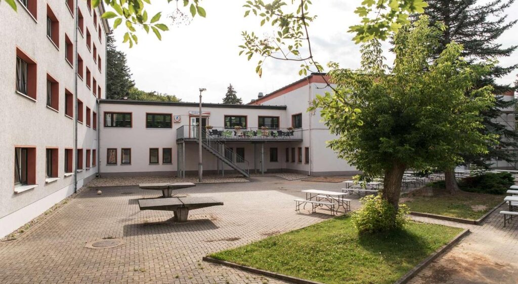 Außenansicht der Jugendherberge Naumburg mit Tischtennisplatten und Sitzbereichen