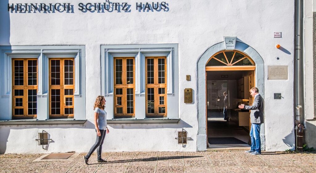 Junge Frau läuft zum Eingang des Heinrich-Schütz-Hauses in Weißenfels