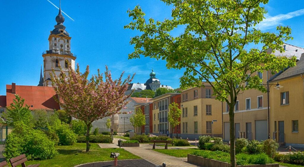 Blick auf den Kirchturm der Stadtkirche St. Marien Weißenfels mit grüner Parkanlage und Sitzmöglichkeiten