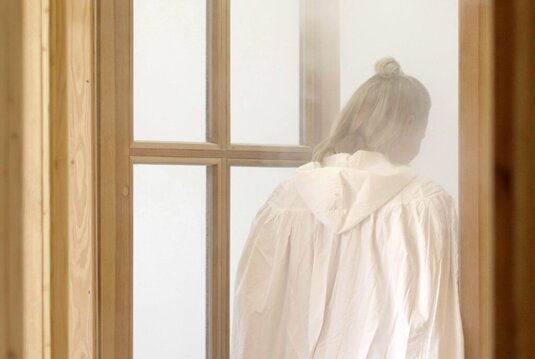 Frau in weißem Umhang betritt die Zerstäuberhalle Bad Sulza