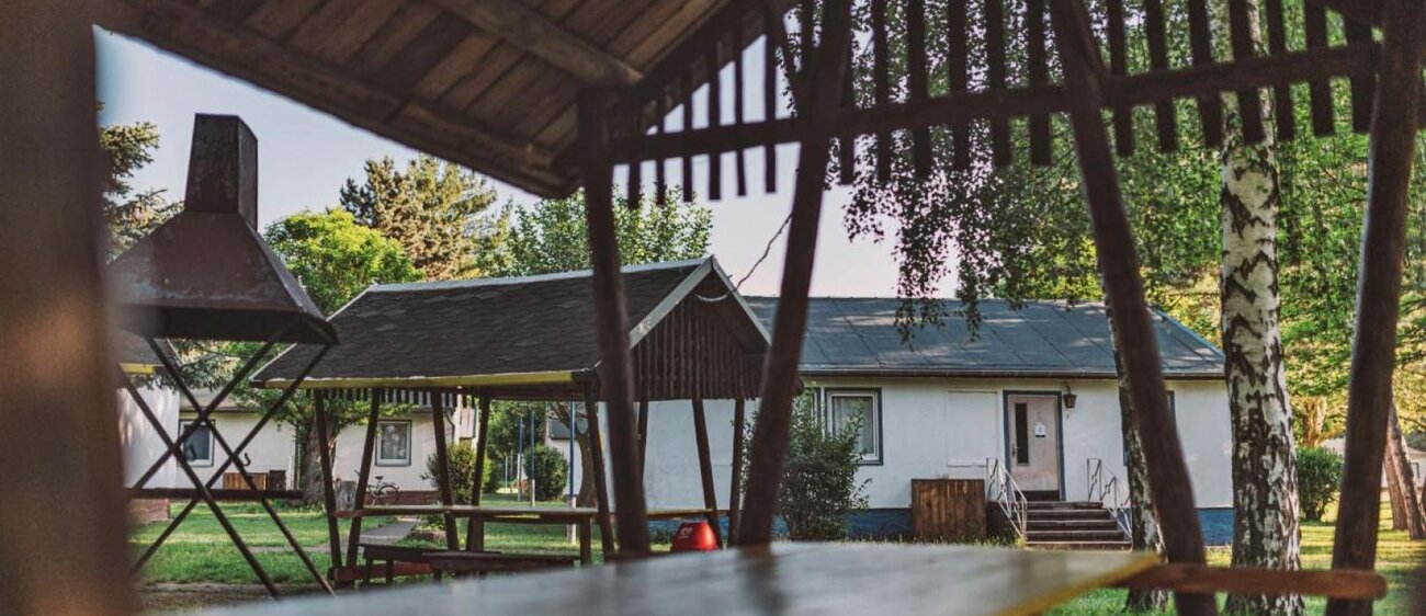 Außenbereich der Jugendherberge Kretzschau mit Ansicht auf Sitzgelegenheiten und Bungalows