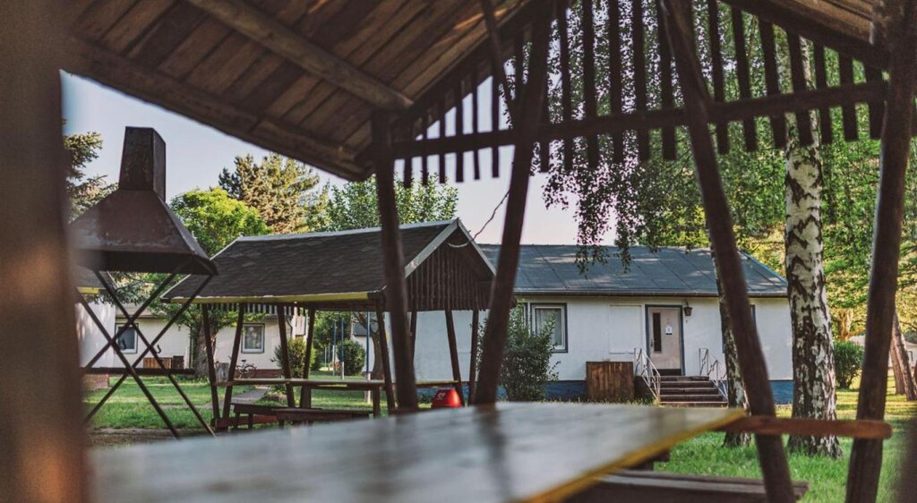 Außenbereich der Jugendherberge Kretzschau mit Ansicht auf Sitzgelegenheiten und Bungalows