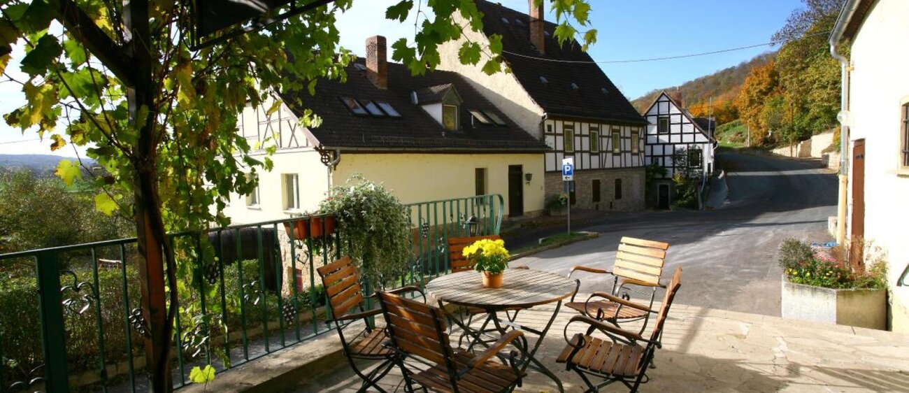 Terrasse der Saalhäuser Weinstuben im Landesweingut Kloster Pforta mit Tisch und Stühlen