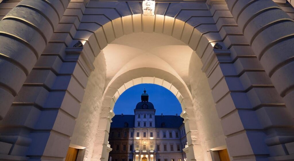 Blick auf Schloss Neu-Augustusburg Weißenfels durch den bei Nacht beleuchteten Torbogen