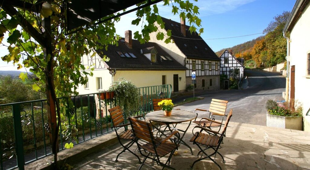 Terrasse der Saalhäuser Weinstuben im Landesweingut Kloster Pforta mit Tisch und Stühlen