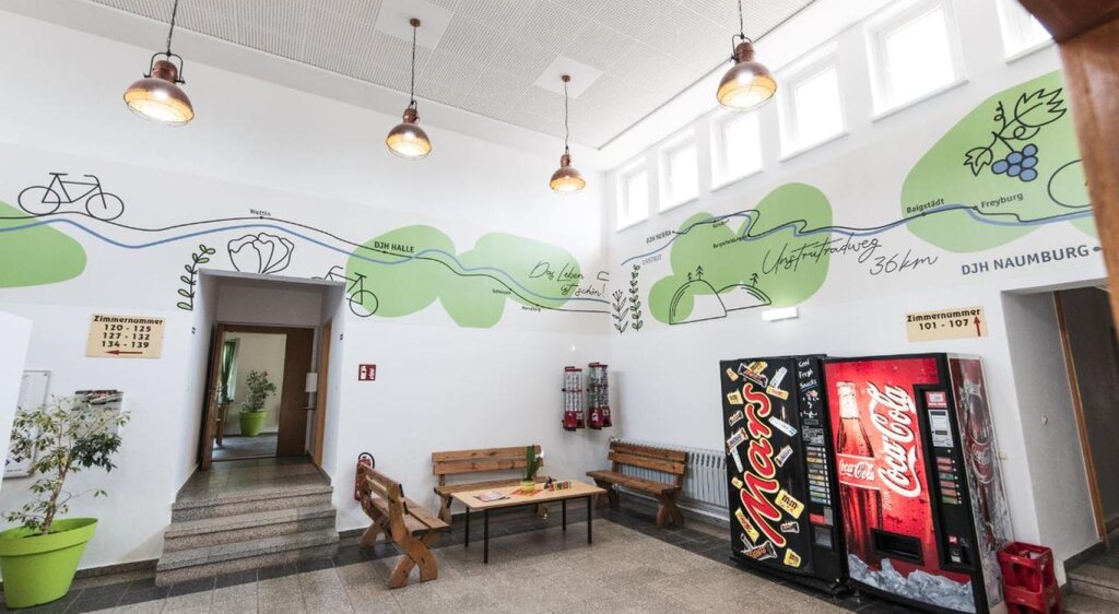 Eingangsbereich der Jugendherberge Nebra mit Sitzgelegenheit und Getränk- und Snackautomat