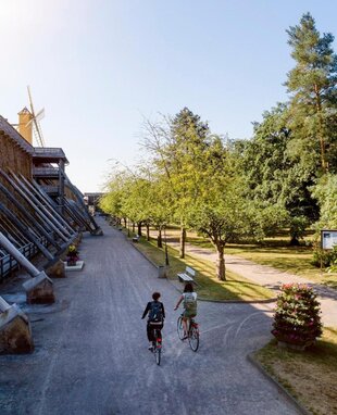 Luftaufnahme des Gradierwerkes in Bad Dürrenberg. Neben dem Gradierwerk fahren zwei Rad Fahrer entlang.