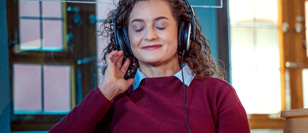 Junge Frau sitzt auf der Hörbank im Heinrich-Schütz-Haus Weißenfels und genießt die Musik