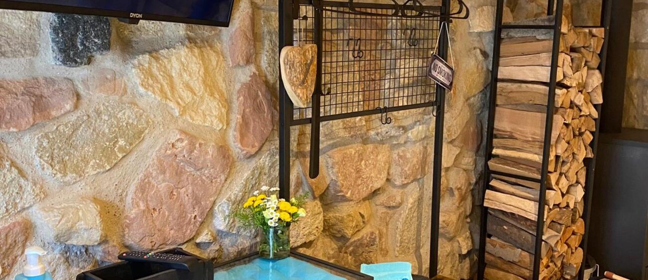 Innenansicht der Ferienwohnung mit Fernseher und Holzstapel