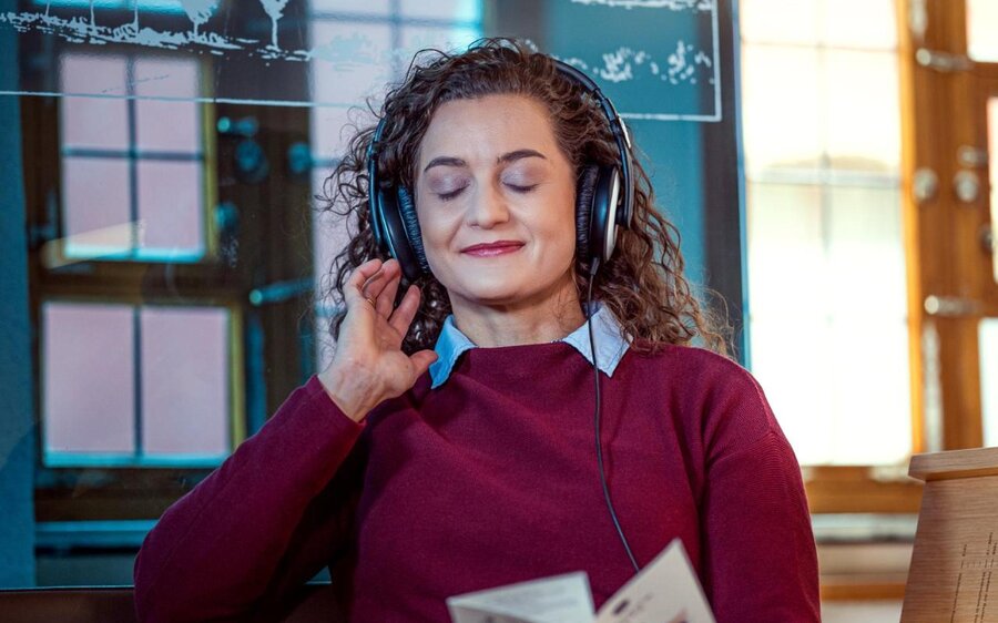 Junge Frau sitzt auf der Hörbank im Heinrich-Schütz-Haus Weißenfels und genießt die Musik