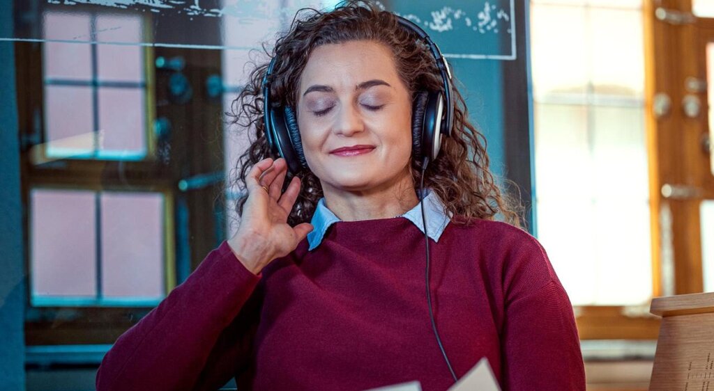 Junge Frau sitzt auf der Hörbank im Heinrich-Schütz-Haus Weißenfels und genießt die Musik