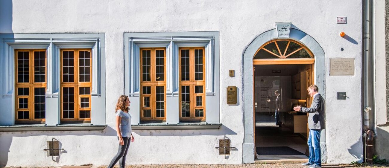Junge Frau läuft zum Eingang des Heinrich-Schütz-Hauses in Weißenfels