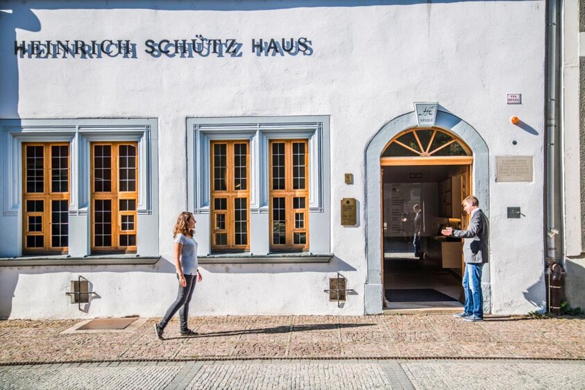 Junge Frau läuft zum Eingang des Heinrich-Schütz-Hauses in Weißenfels