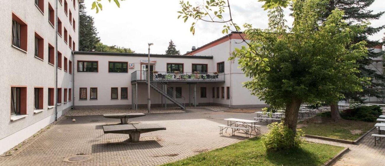 Außenansicht der Jugendherberge Naumburg mit Tischtennisplatten und Sitzbereichen