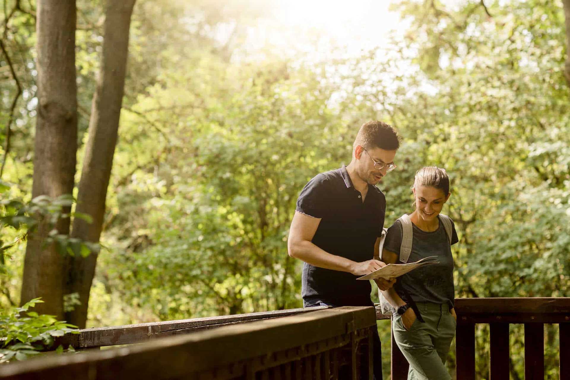 Couple looks at map in the forest