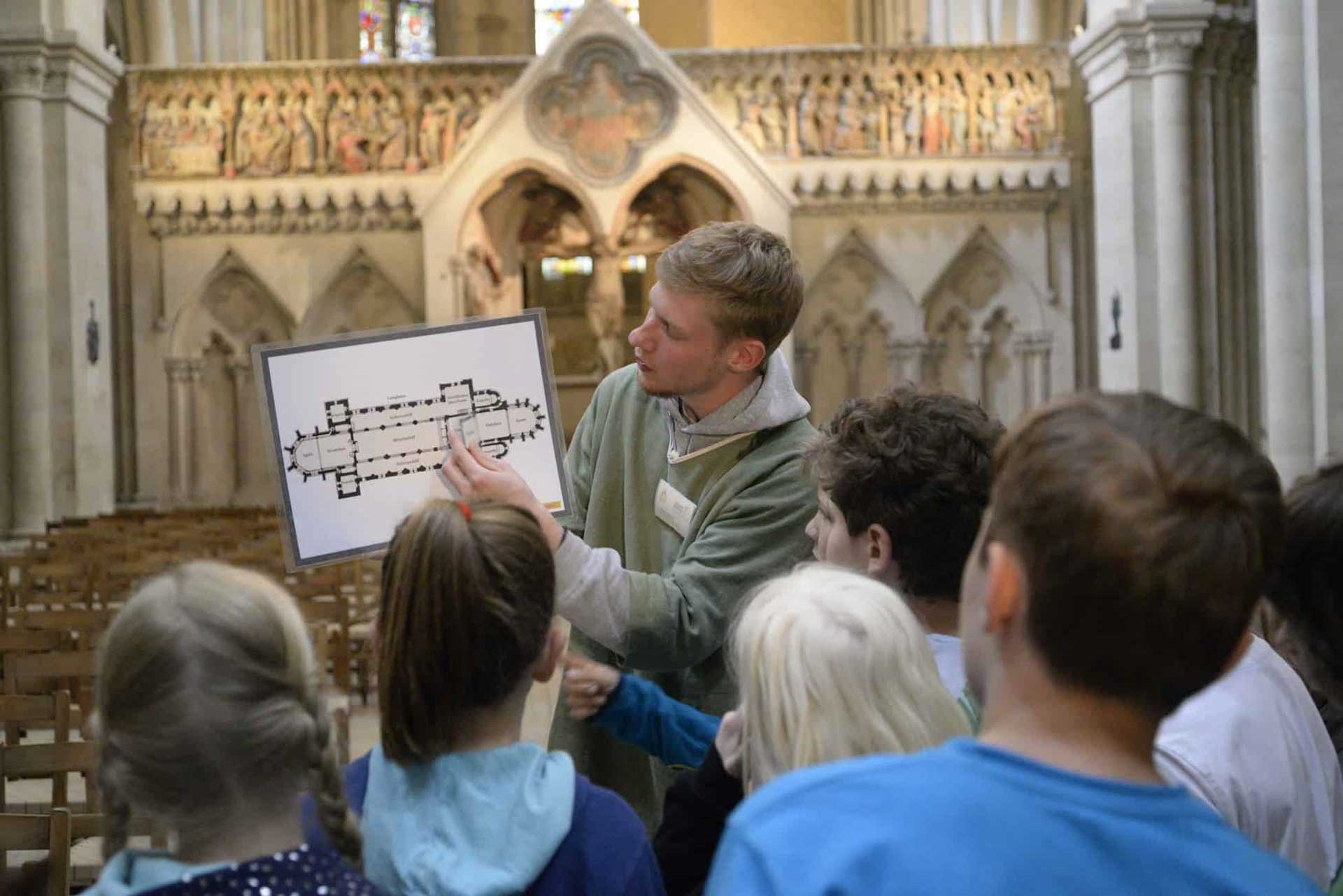 Rondleider toont kinderen de structuur van de kathedraal